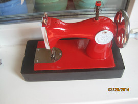 Ярко красная детская швейная машинка производство начала 1960-ых